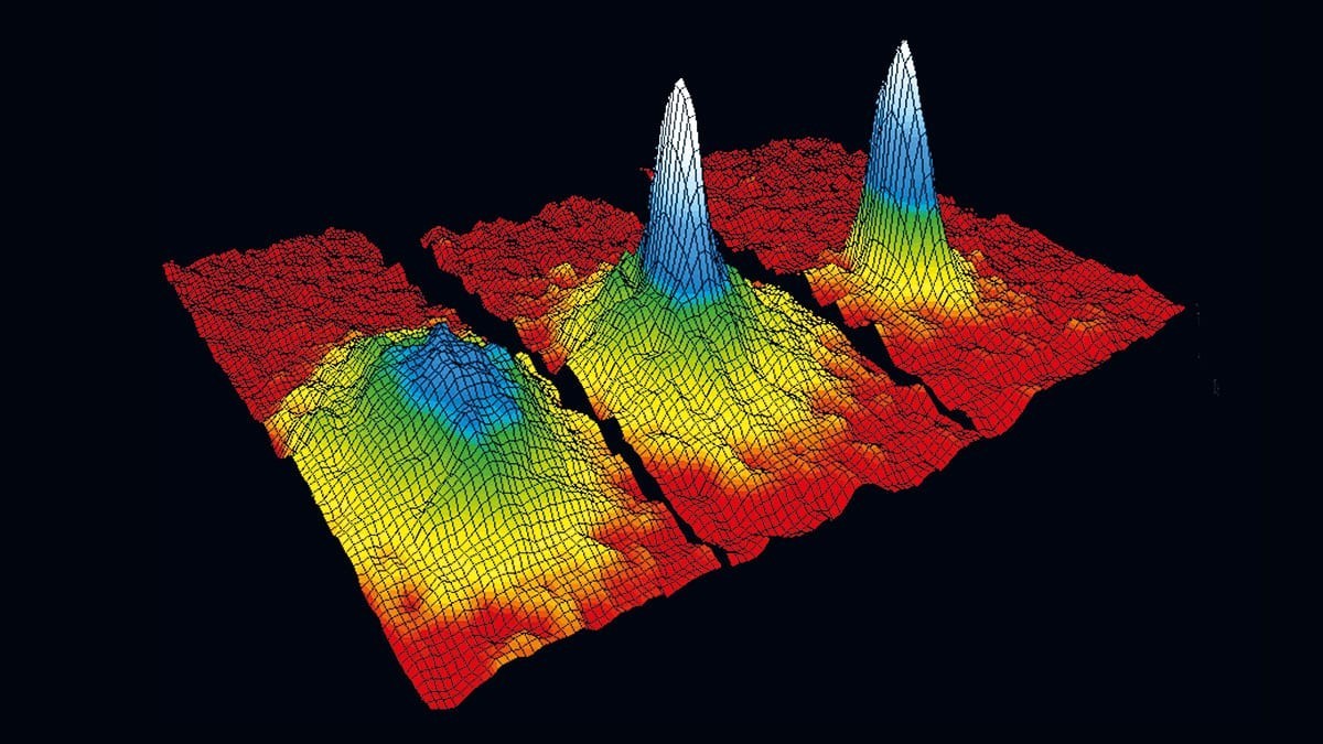 The density of the atomic cloud is shown, with temperature decreasing from left to right. The high peak, the Bose-Einstein condensate, emerges above the other atoms.