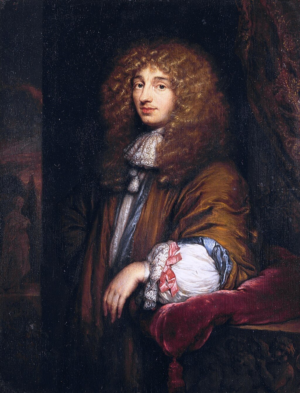 Painted portrait of Christiaan Huygens. Huygen, who has shoulder-length, blonde, curly hair looks blankly at the viewer. Huygen is wearing 1600s era attire with a neckerchief and a brown robe over white, puffy sleeves, Huygen leans on the left arm which is resting on a red velvet pillow. 