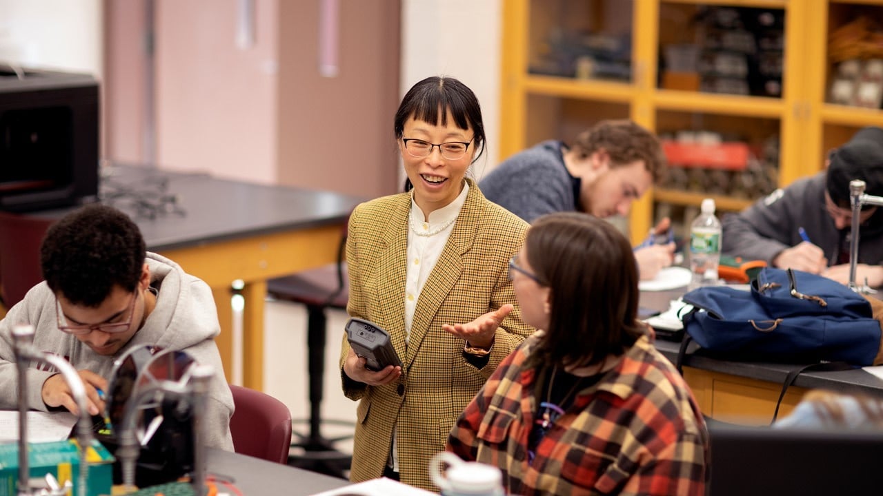 A college physics instructor, Lily Li, talks to a student