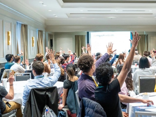 Student attendees raising their hands at an APS event on "Getting a Physics Job"