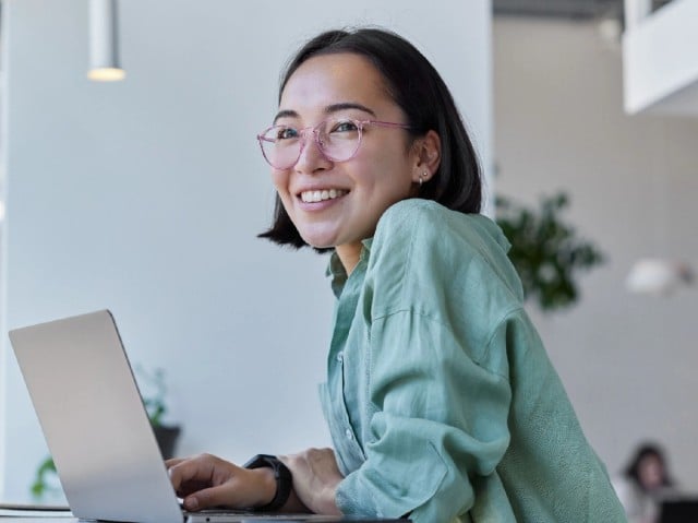 A woman working at a laptop computer.