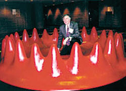 fest08.jpg - 14962 Bytes AIP Executive Officer Marc Brodsky crouches in the quantum corral, part of the Physics Works! exhibit at the Georgia World Congress Center (GWCC). 