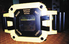 Physics research drives technology, as illustrated by this giant watch with liquid crystal face. Displayed on its reverse are a number of everyday items made possible through physics research. 