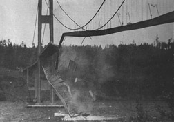 Screw-up #6: A few minutes after the first piece of concrete fell, this 600 foot section broke out of the suspension span, turning upside down as it crashed in Puget Sound. Note how the floor assembly and the solid girders have been twisted and warped. The square object in mid air (near the centre of the photograph) is a 25 foot (7.6m) section of concrete pavement. Notice the car in the top right corner.
