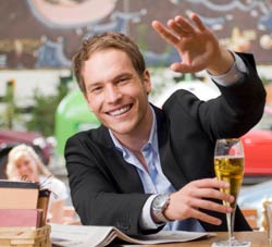 man in bar waving to attract attention