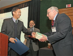 Chenggang Xu (left) presents APS President Arthur Bienenstock (right) with a copy of the three-volume Chinese translation of Einstein's collected works