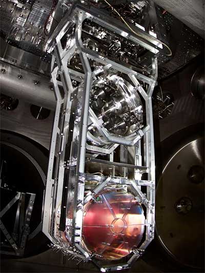 The photo shows one of LIGO's mirrors, which reflect the laser beams along the lengths of the detector arms. The 40 kg mirror is suspended below the metal mass above by 4 silica glass fibers.
